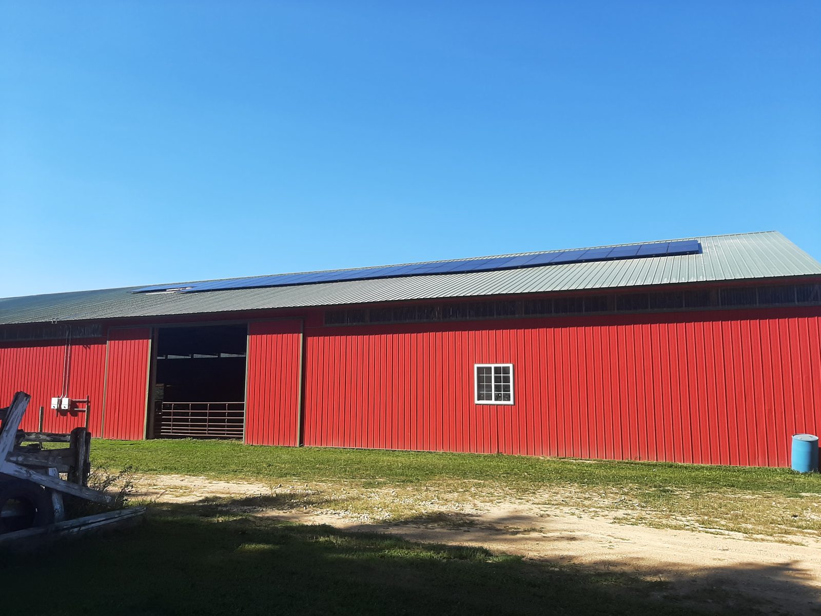 Solar panels along the roof of a red barn