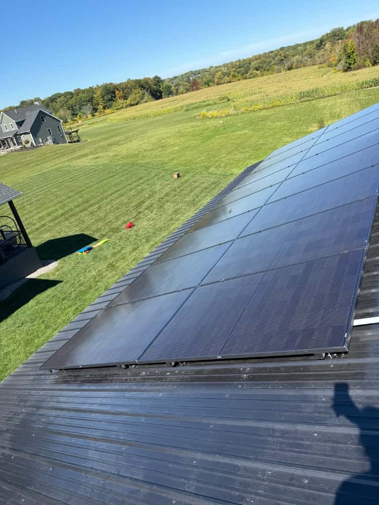 Solar panels on a metal roof overlooking fields