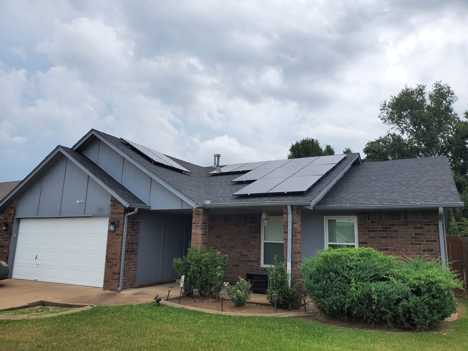Solar panels on several roof faces of a brick home